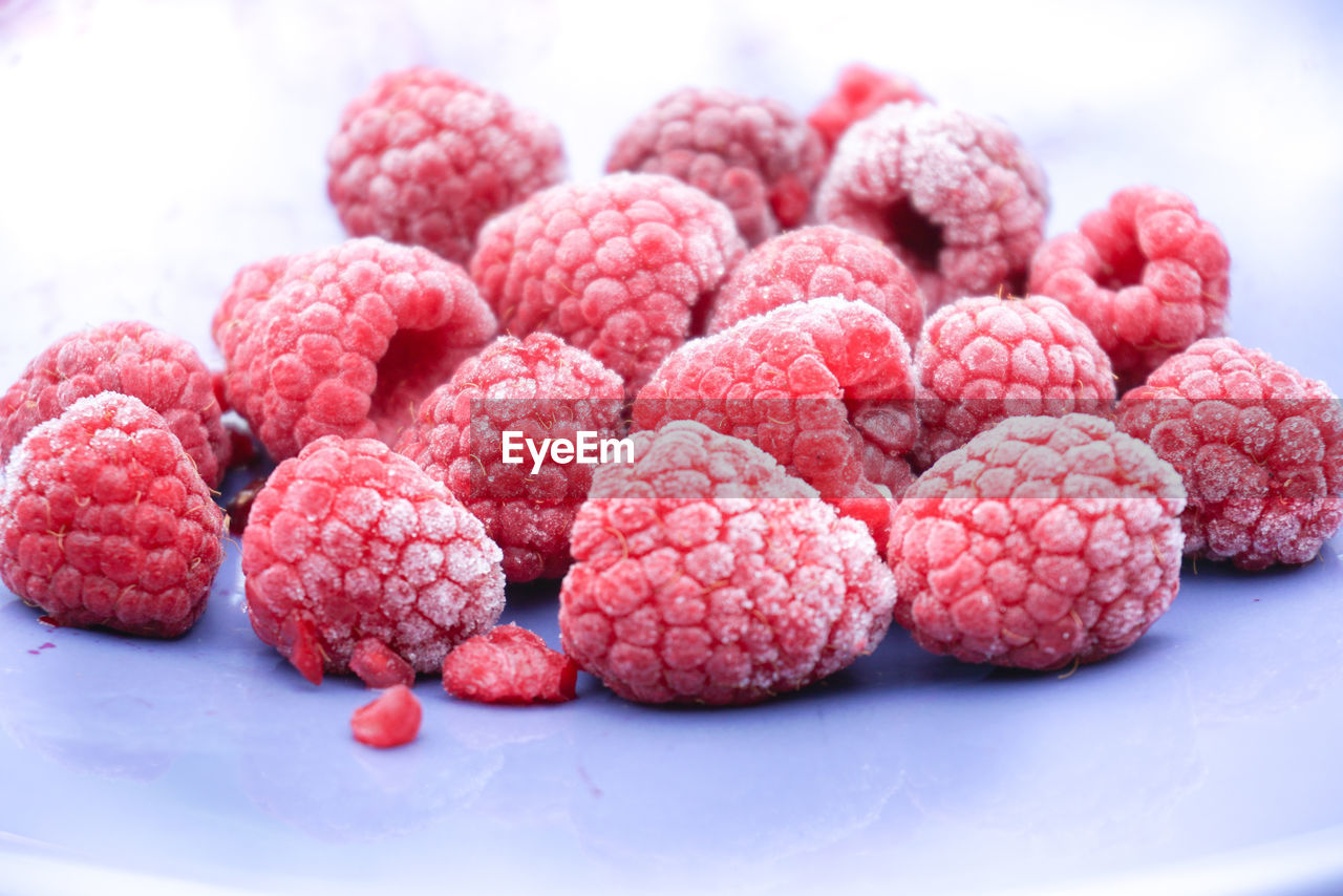 Frozen raspberry on blue plate