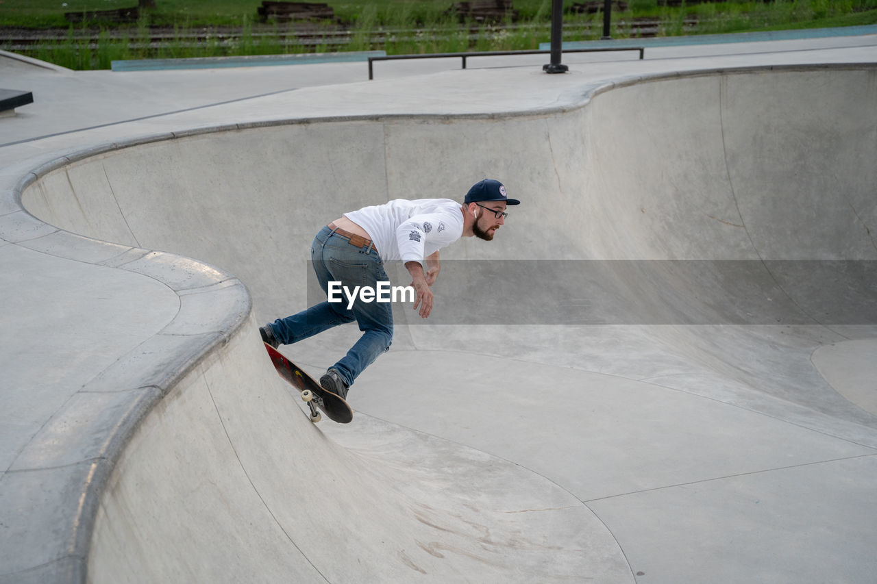 FULL LENGTH OF MAN RIDING SKATEBOARD