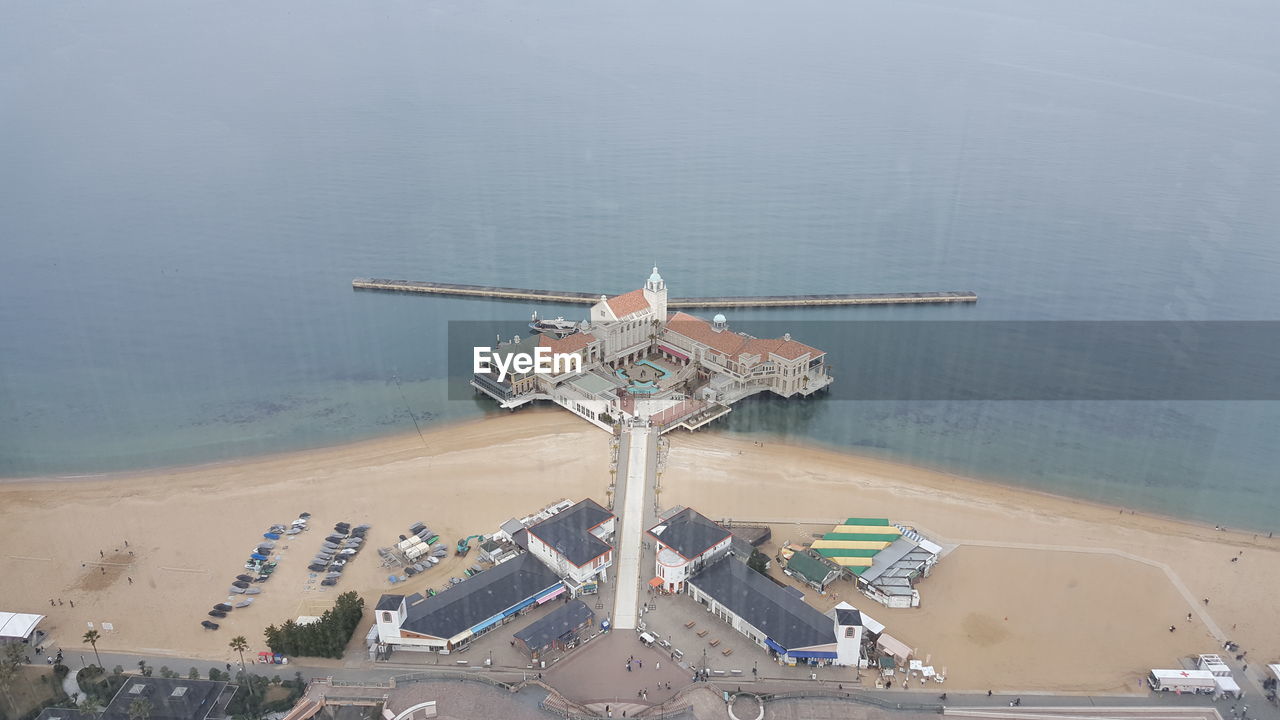 HIGH ANGLE VIEW OF CARS ON BEACH AGAINST SKY