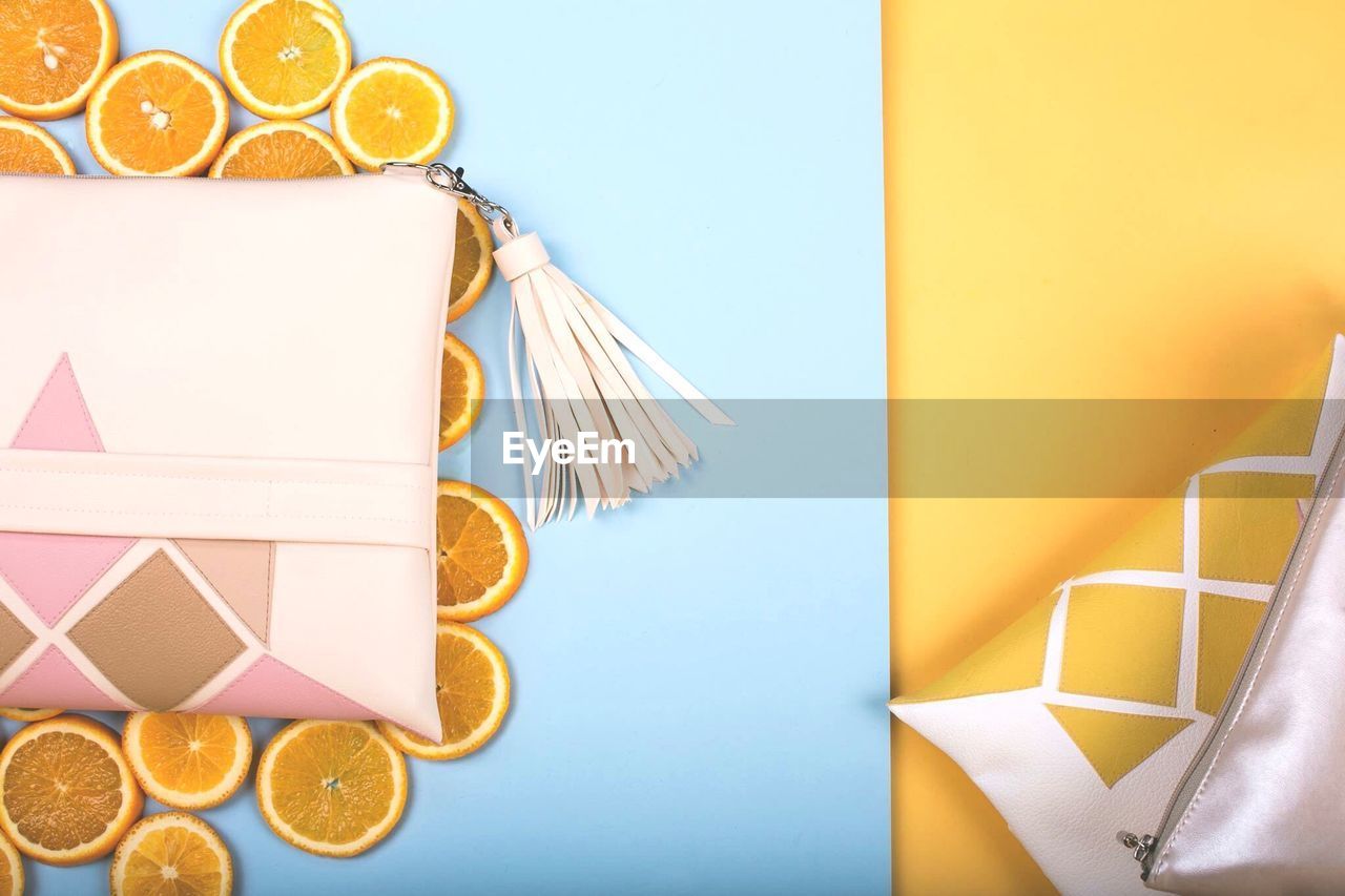 Directly above shot of purses with orange slices on table