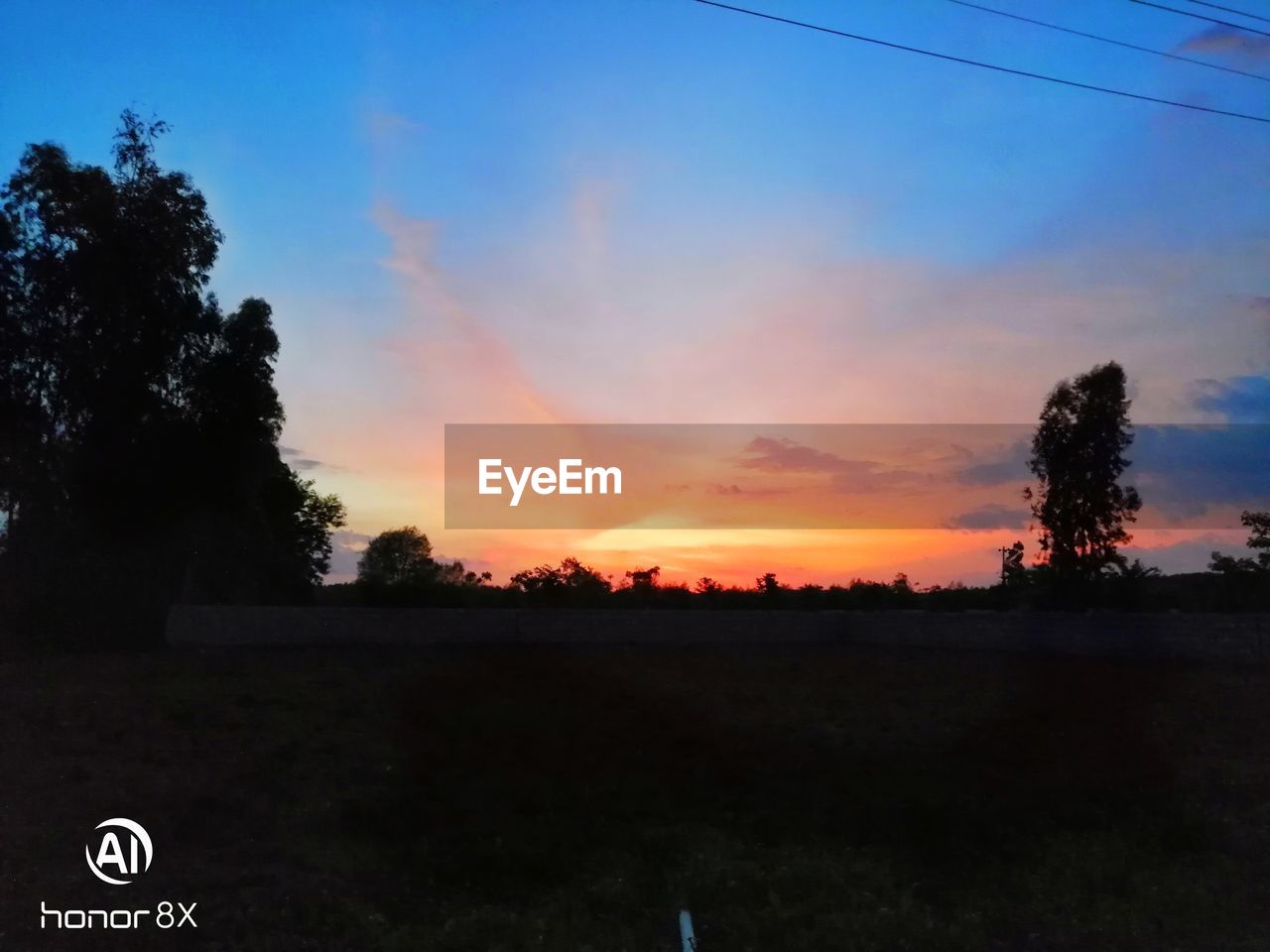 SCENIC VIEW OF SILHOUETTE FIELD AGAINST SKY AT SUNSET