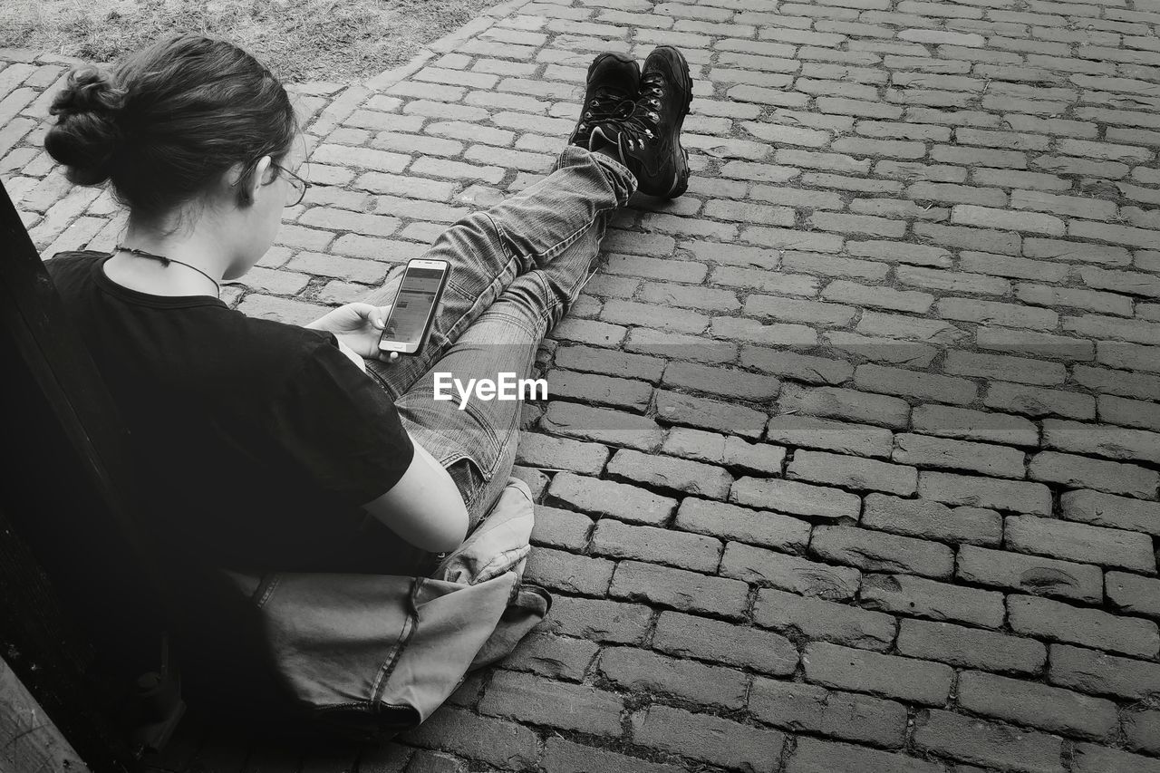 HIGH ANGLE VIEW OF COUPLE SITTING ON FOOTPATH