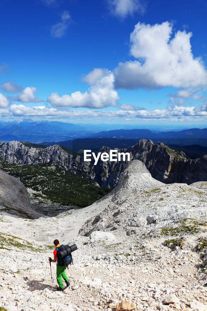 Man climbing on mountain against sky