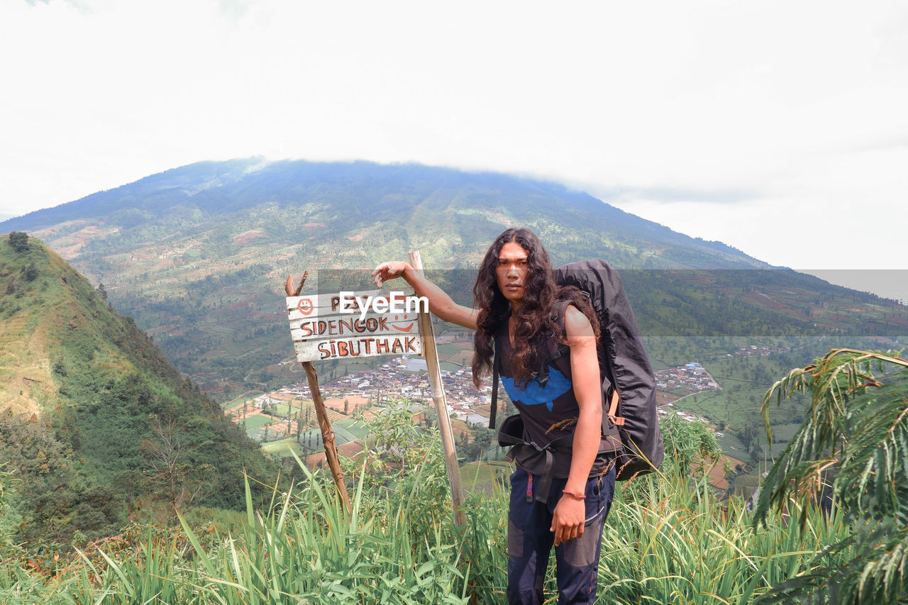 Long haired male climber with big mountain backpack