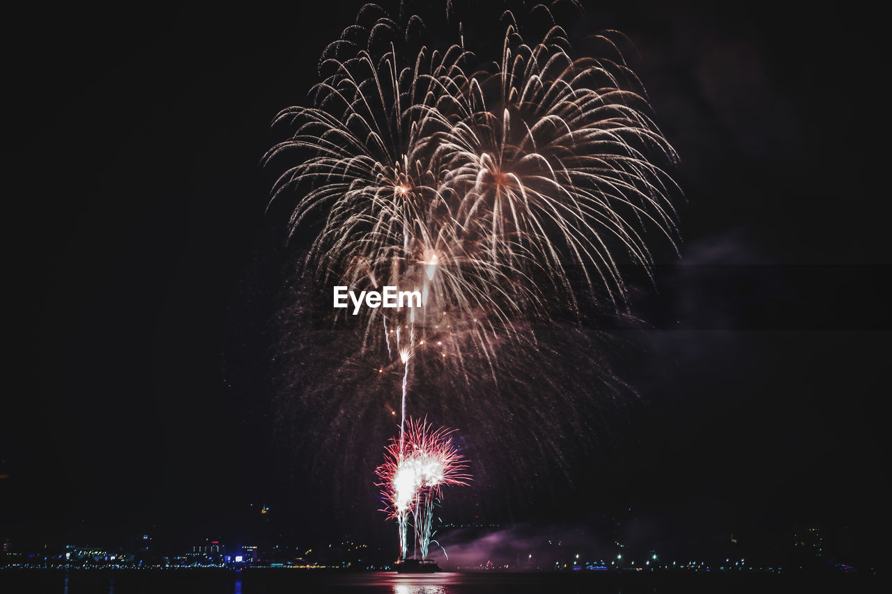 Low angle view of firework display at night