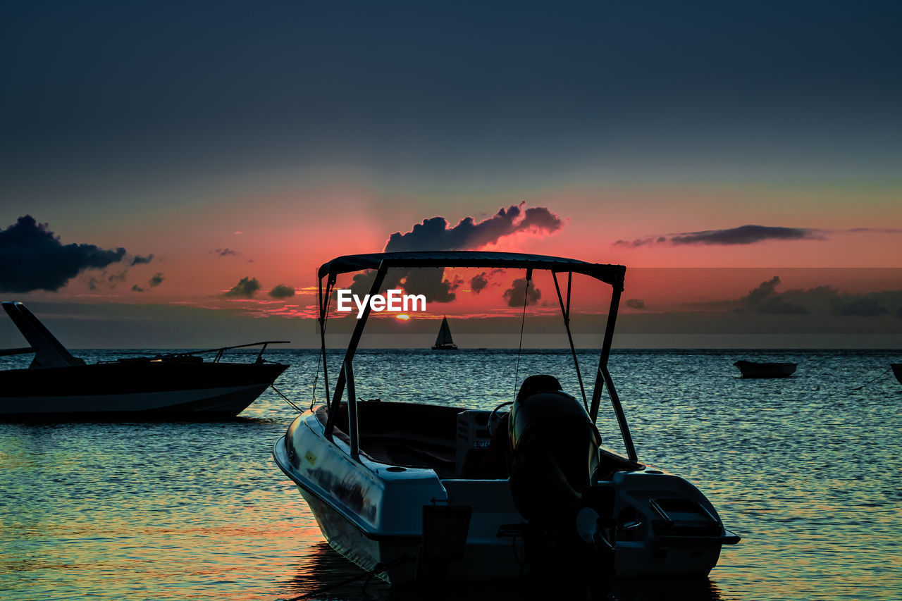 SILHOUETTE BOAT IN SEA AGAINST ORANGE SKY