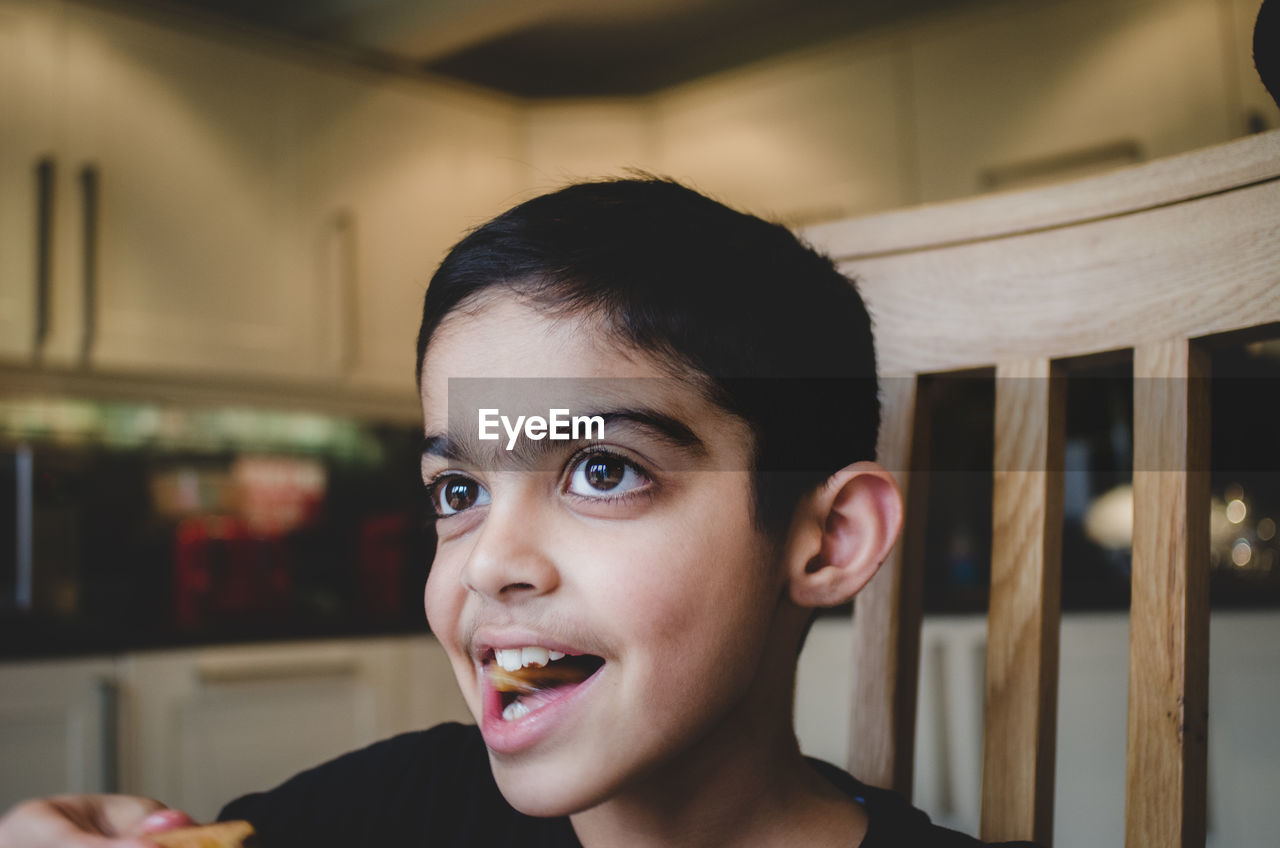 PORTRAIT OF BOY LOOKING THROUGH CAMERA