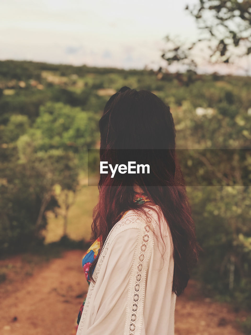 Side view of woman standing against trees