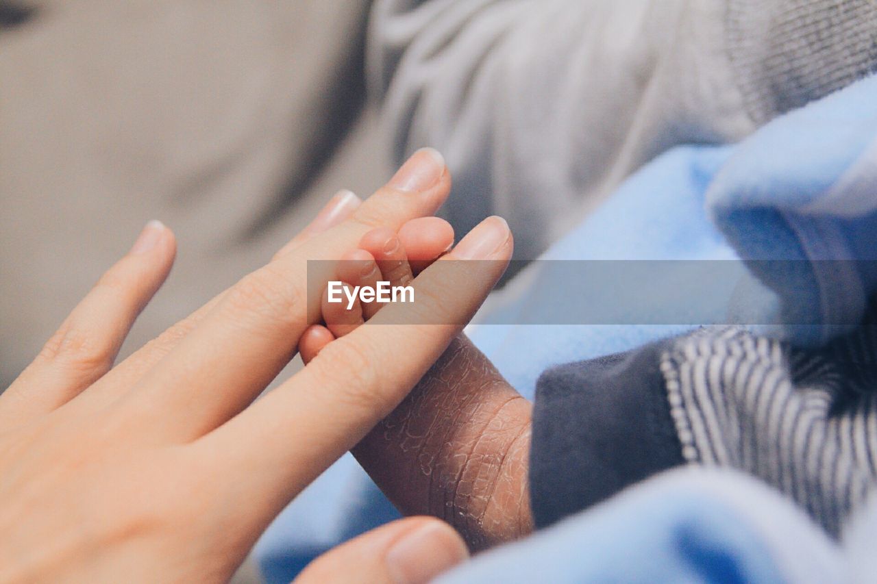 Close-up of mother holding newborn baby feet