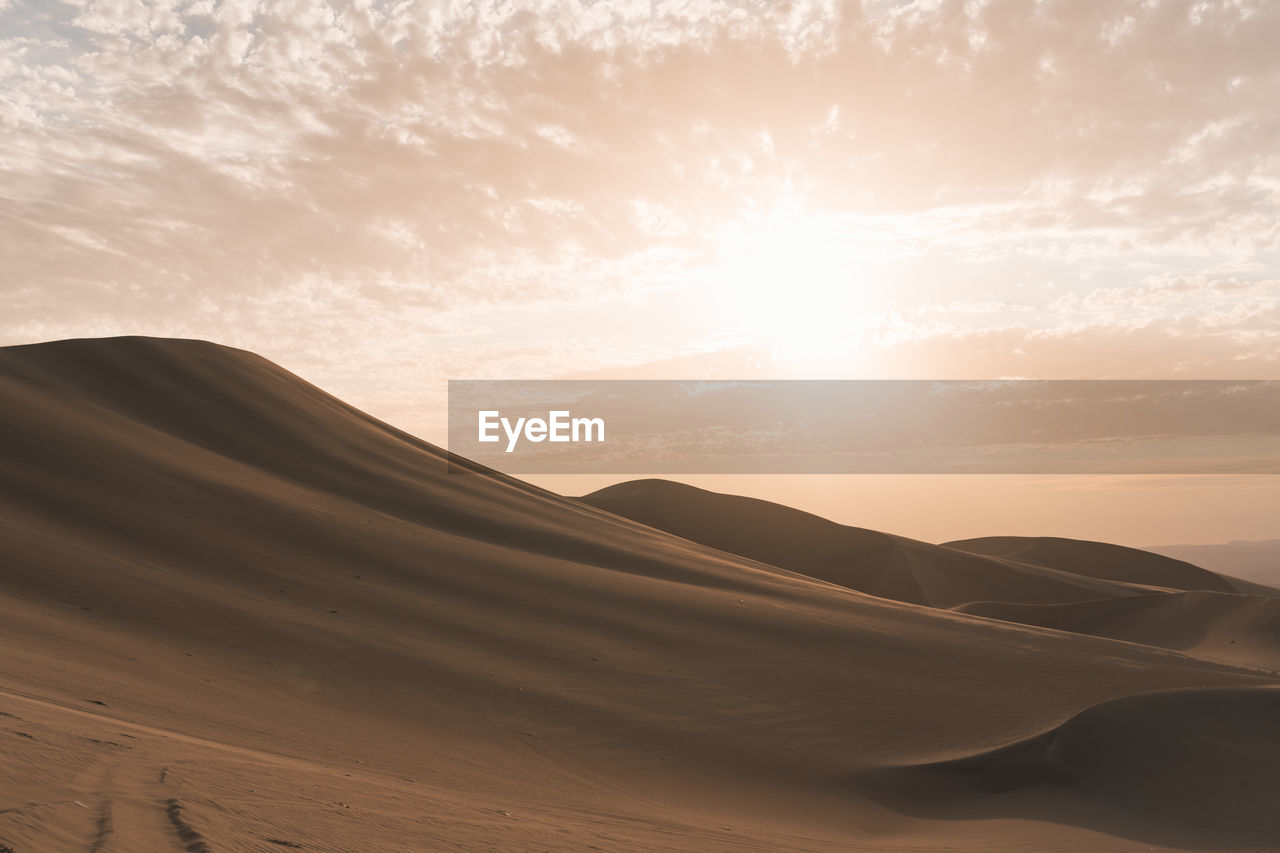 Scenic view of desert against sky during sunset