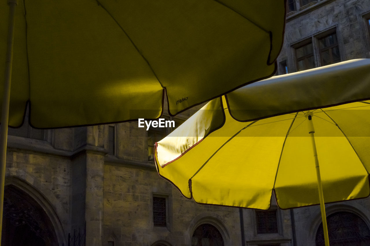 LOW ANGLE VIEW OF YELLOW LAMP AGAINST BUILDING