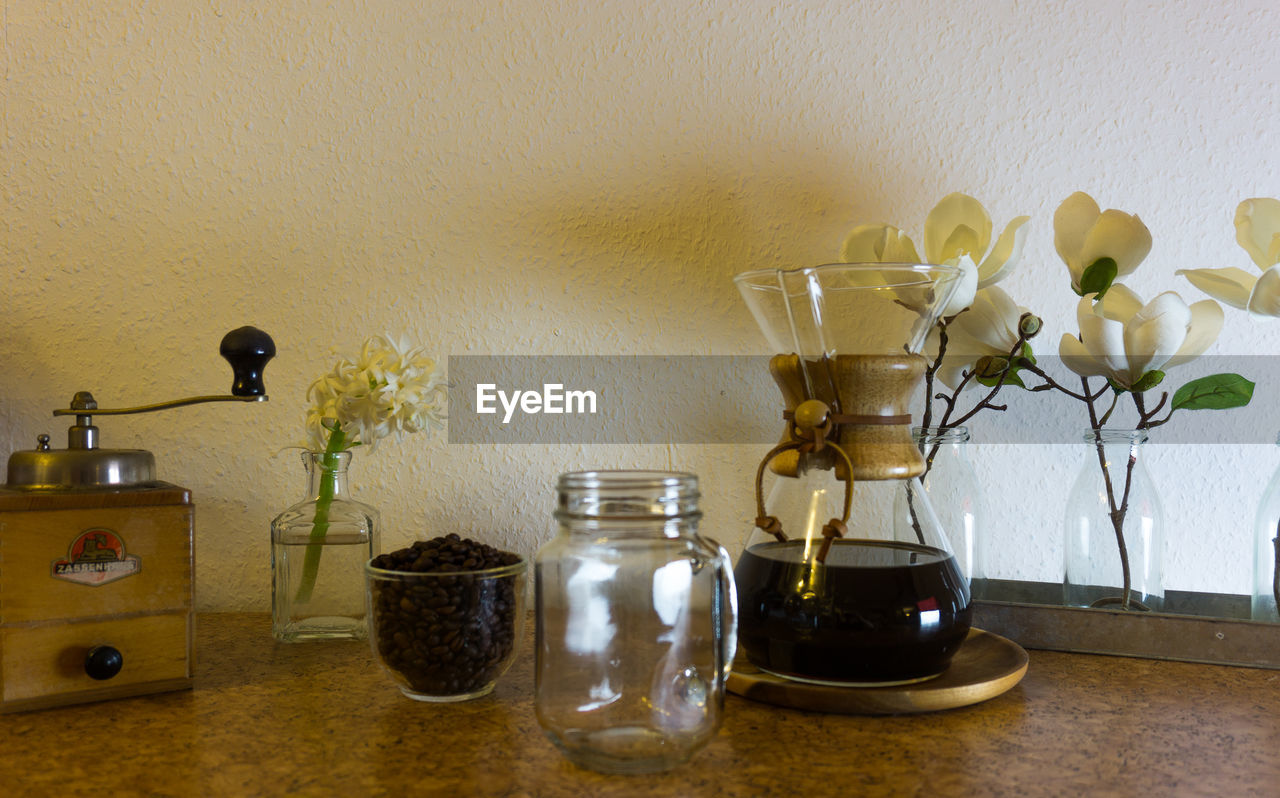 FLOWER VASE ON TABLE AGAINST WALL