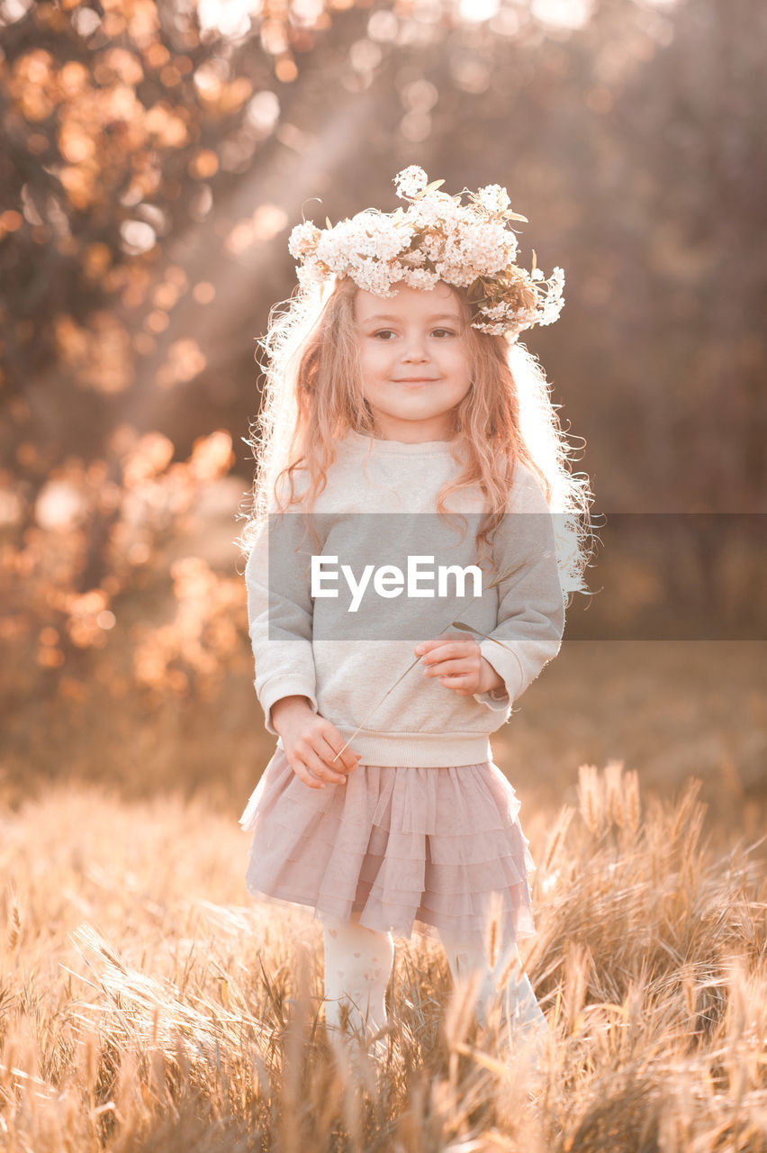 plant, blond hair, one person, women, nature, child, childhood, hairstyle, smiling, portrait, long hair, happiness, clothing, field, grass, rural scene, female, land, emotion, sunlight, fashion, autumn, landscape, innocence, summer, dress, portrait photography, standing, flower, cute, crown, meadow, outdoors, adult, toddler, beauty in nature, looking at camera, front view, royalty, sky, flowering plant, day, copy space, tree, plain, environment, spring, cheerful, three quarter length, white, sunset, back lit, wreath, carefree, looking, cereal plant, agriculture, positive emotion, springtime, person, selective focus, fun
