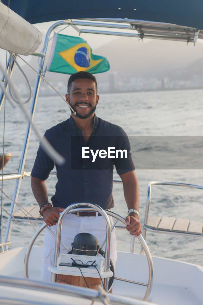 Portrait of young man driving boat in river