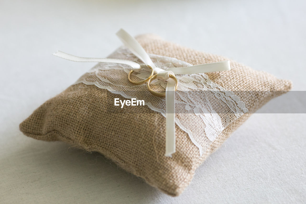 High angle view of wedding rings on pillow