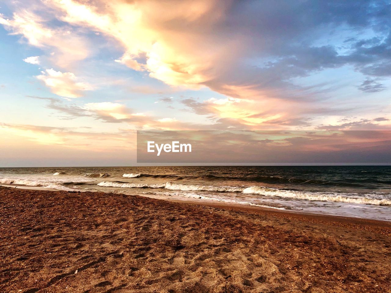 SCENIC VIEW OF BEACH DURING SUNSET