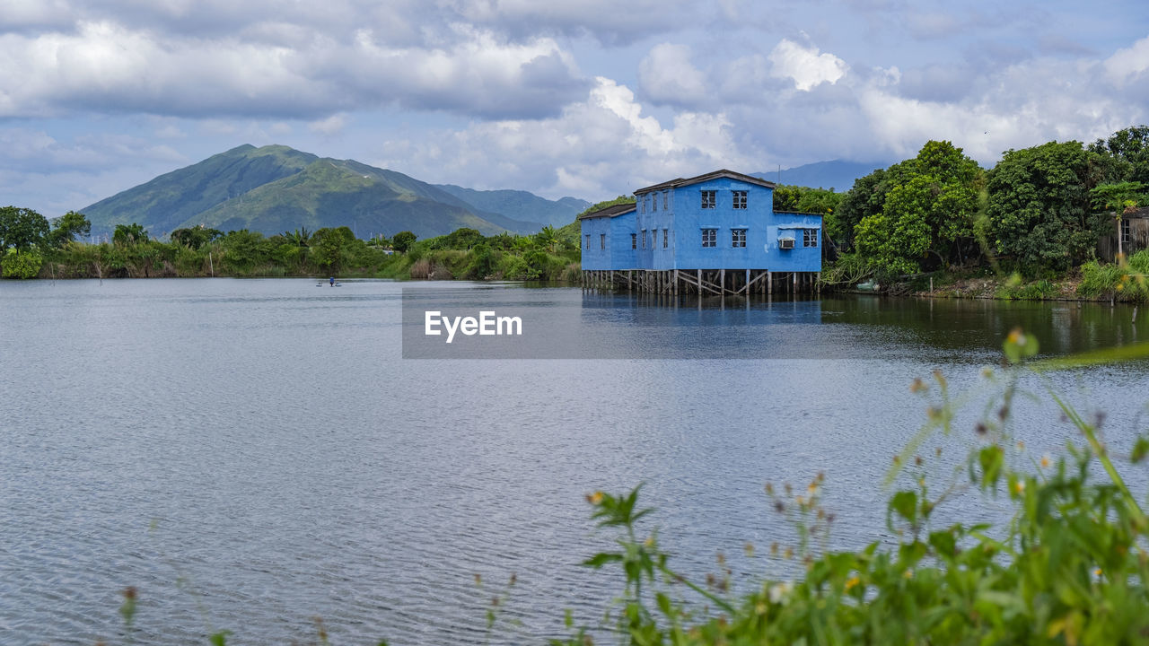 SCENIC VIEW OF LAKE BY BUILDING AGAINST SKY