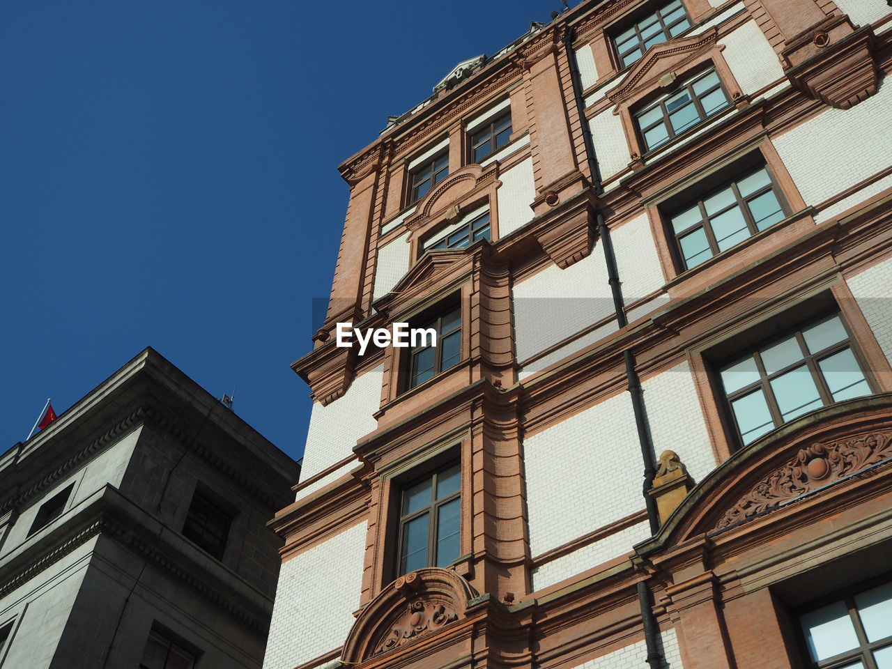 Low angle view of building against clear blue sky