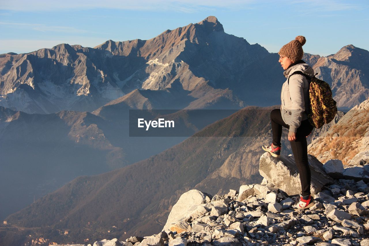 Woman standing on mountain against sky