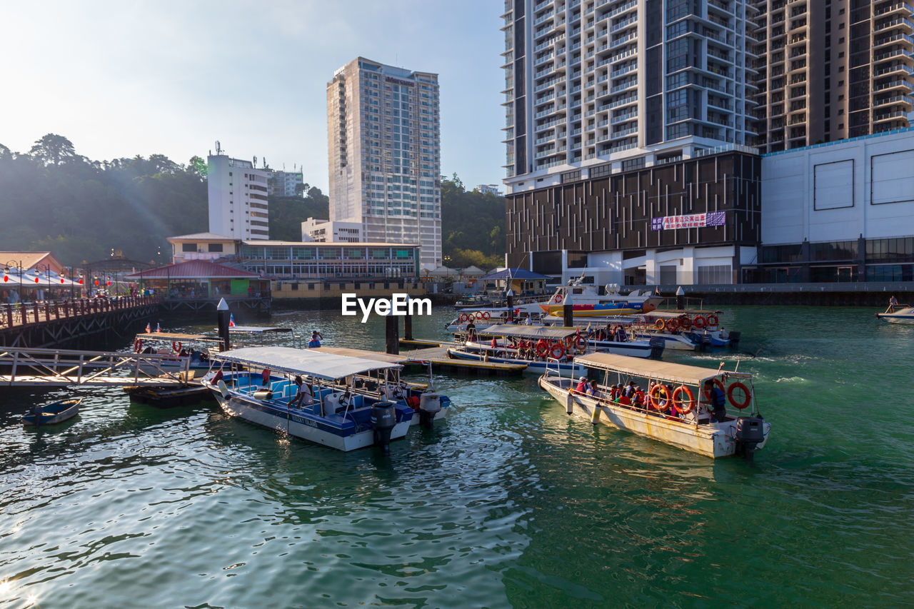 BOATS IN RIVER AGAINST BUILDINGS