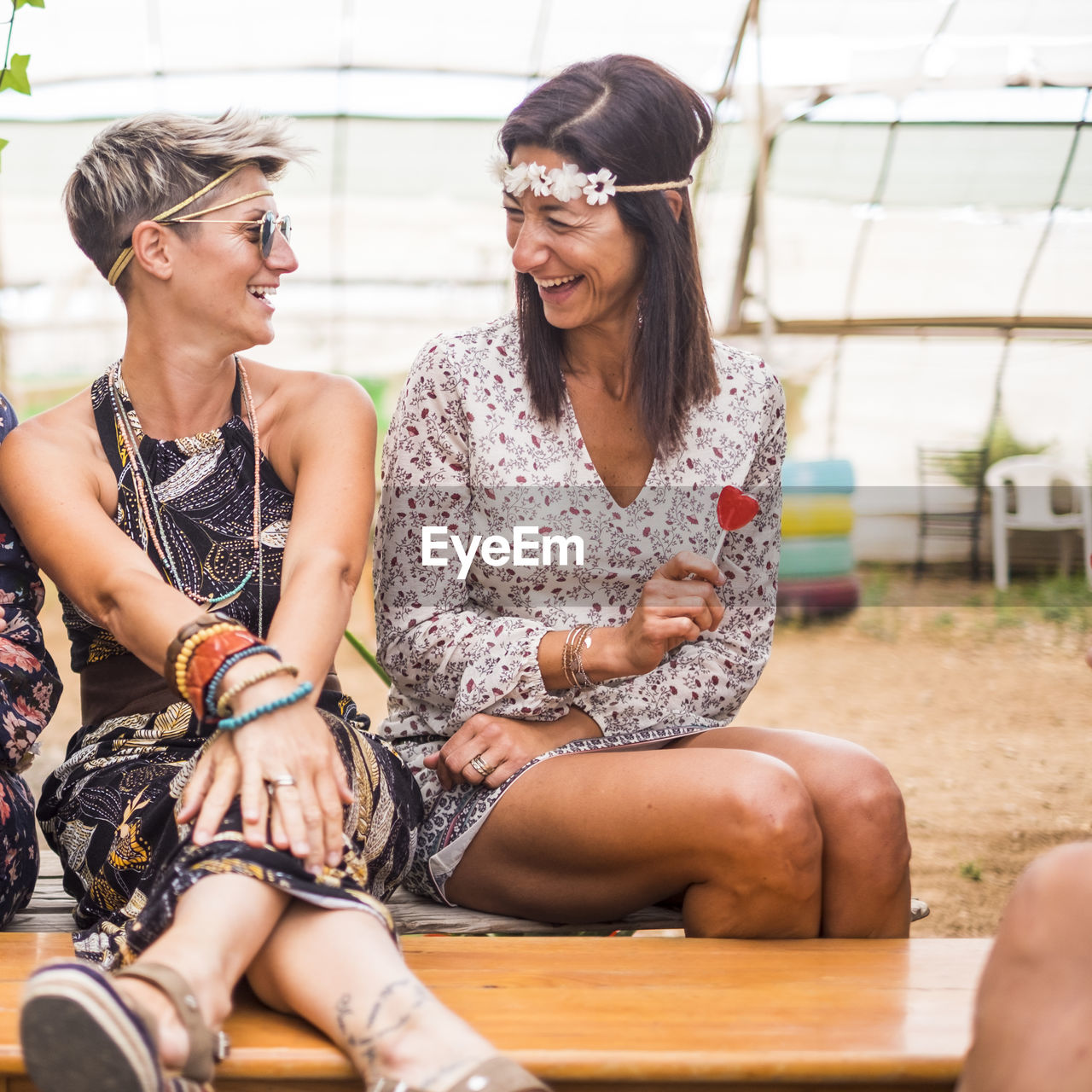 Happy friends talking while sitting on table in yard