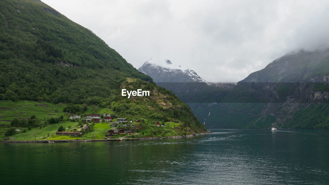 Scenic view of mountains and lake against cloudy sky