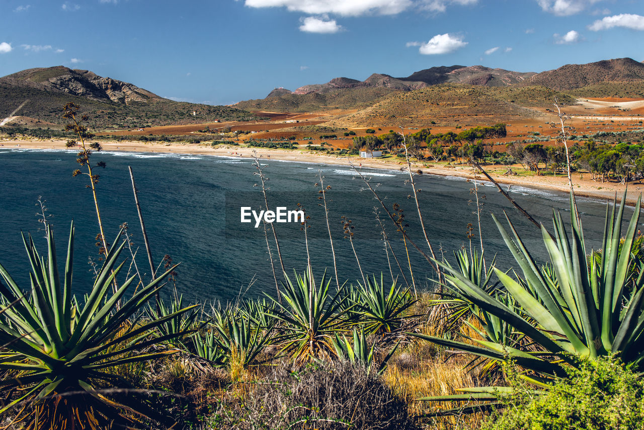 Scenic view of land and mountains against sky