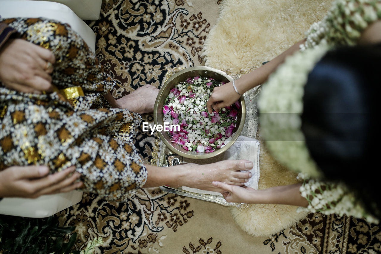 High angle view of bride washing woman legs on floor