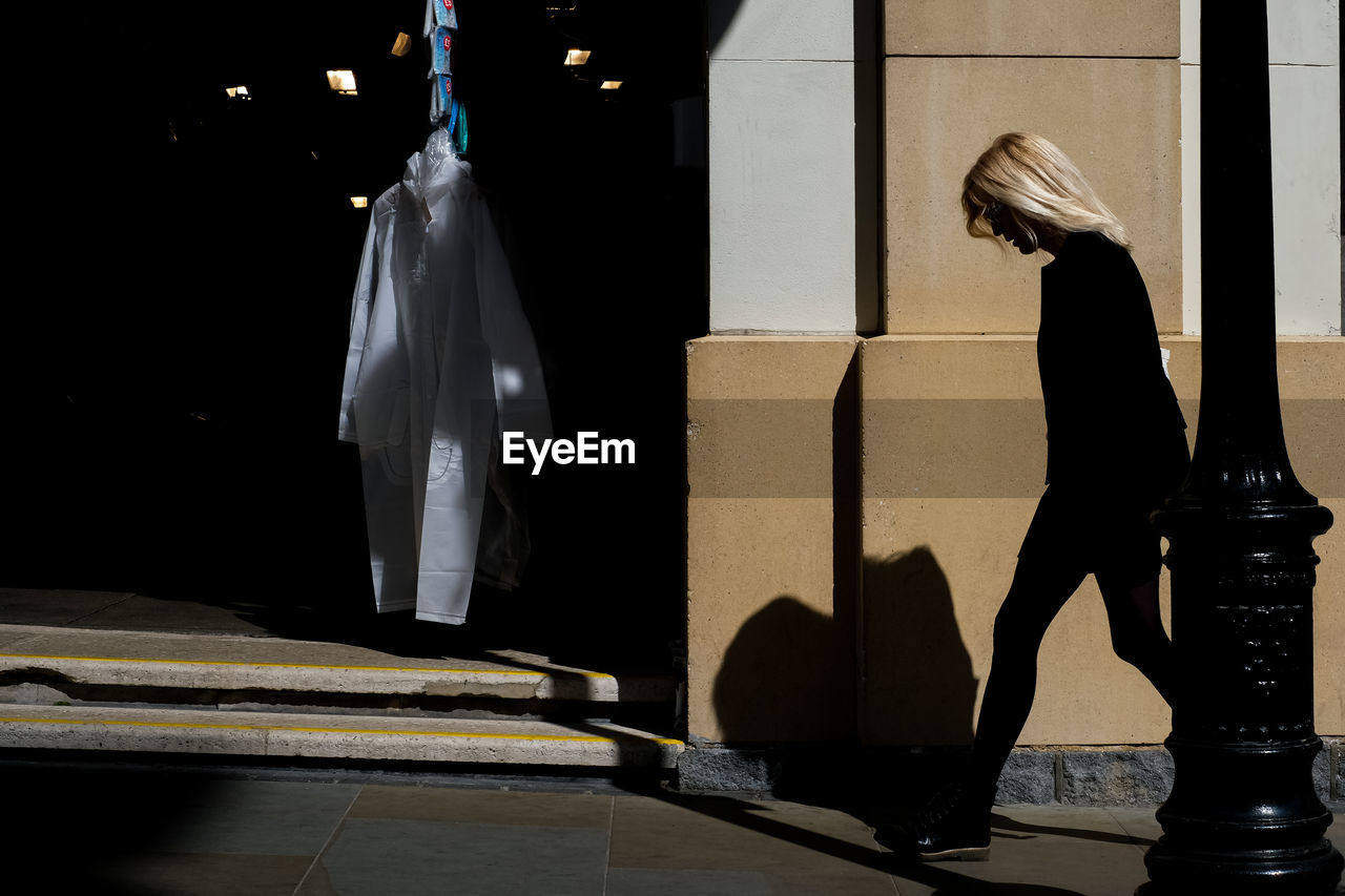 black, light, shadow, clothing, darkness, adult, architecture, one person, performance art, white, statue, bag, full length, women, person