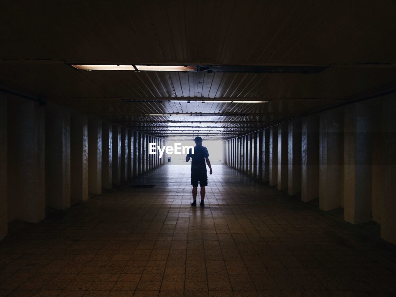 WOMAN WALKING IN TUNNEL