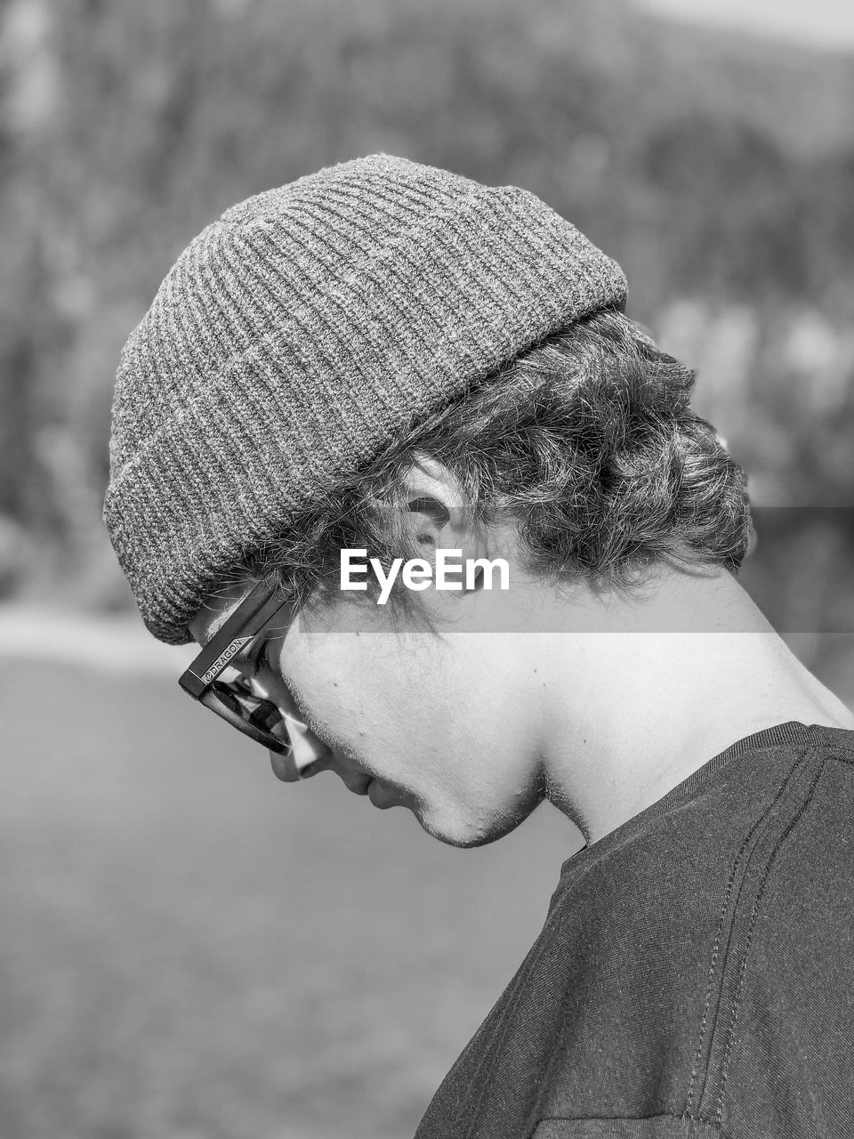 Profile view of young man wearing knit hat while standing on field