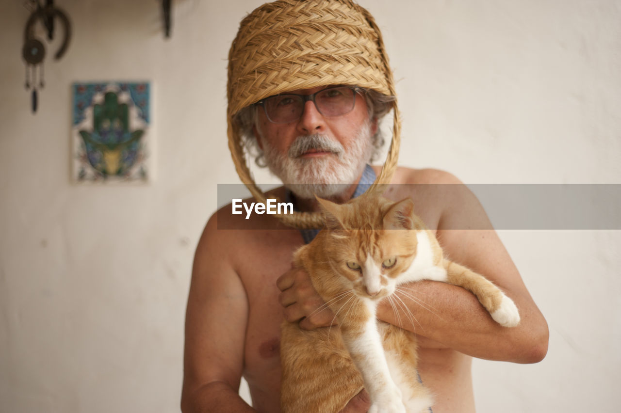 PORTRAIT OF MAN WITH CAT IN MOUTH