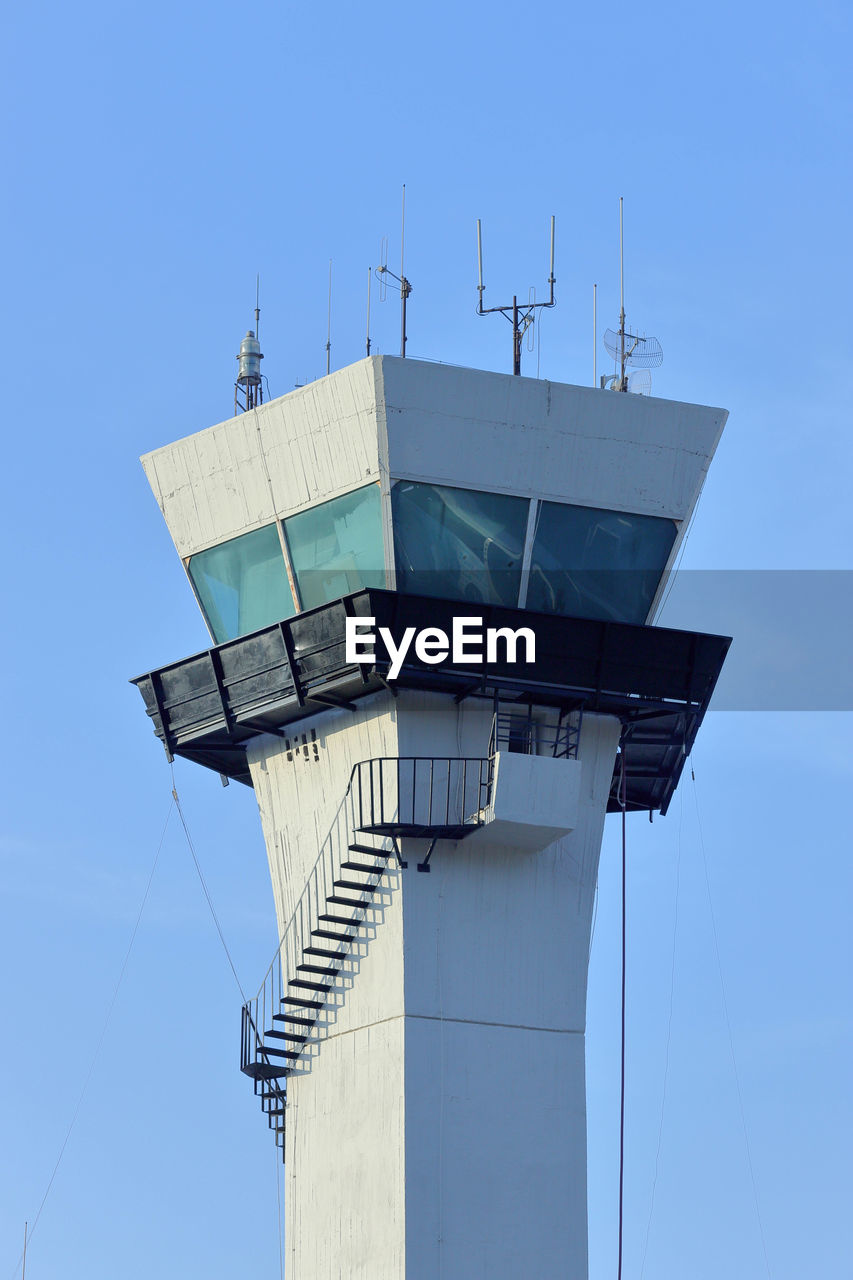 Low angle view of communications tower against clear blue sky