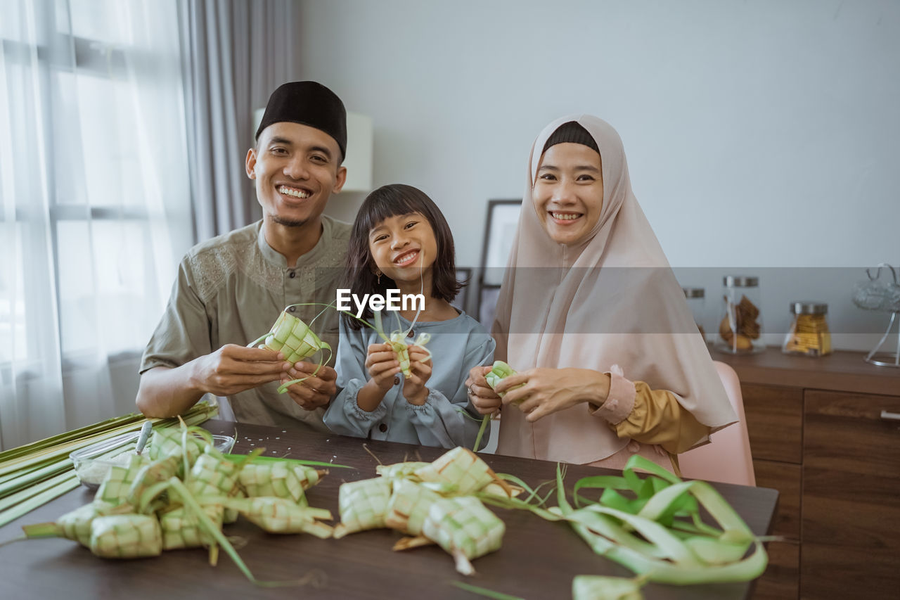 portrait of family sitting on table at home