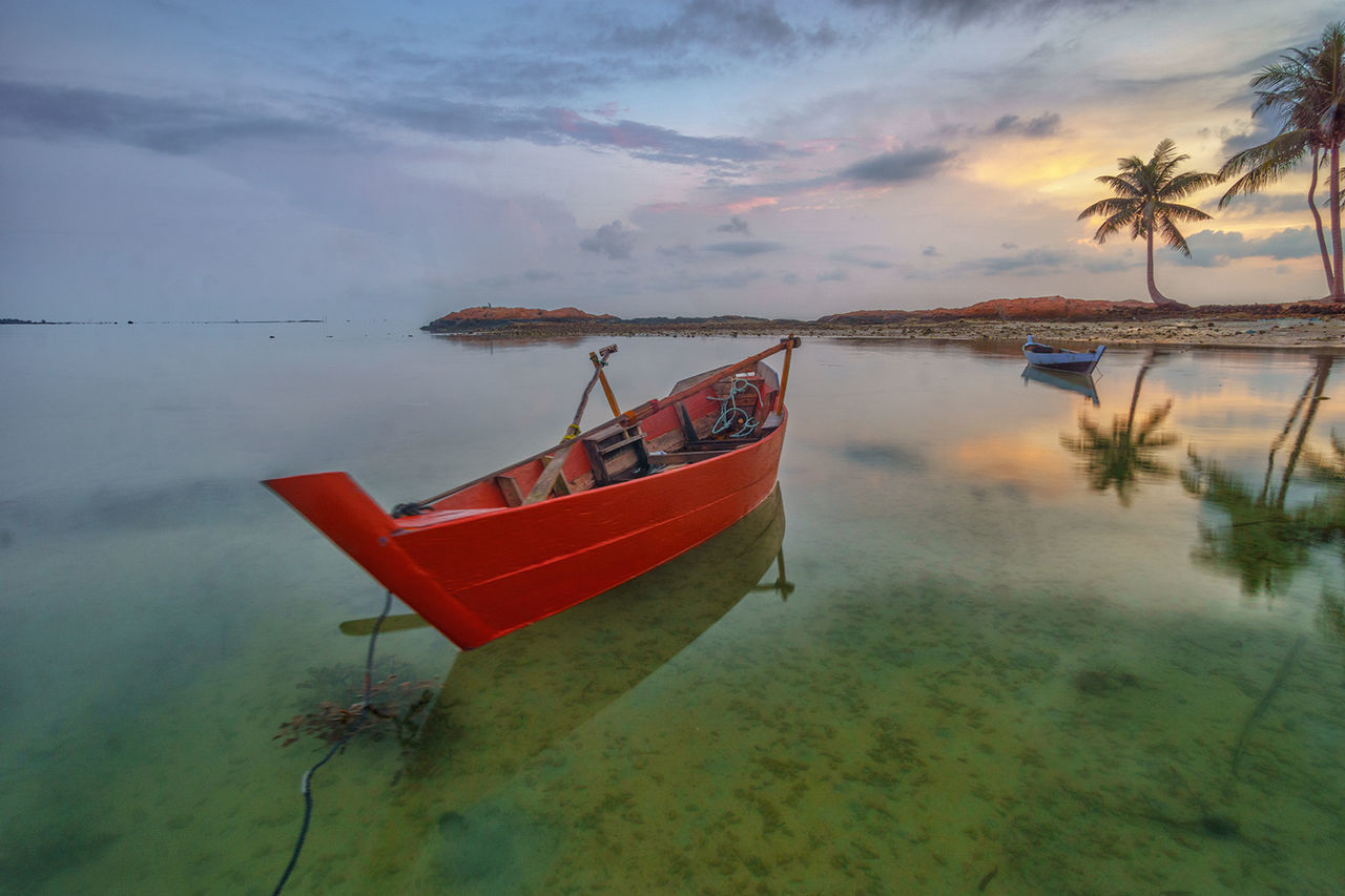 Boat moored on sea against sky during sunset