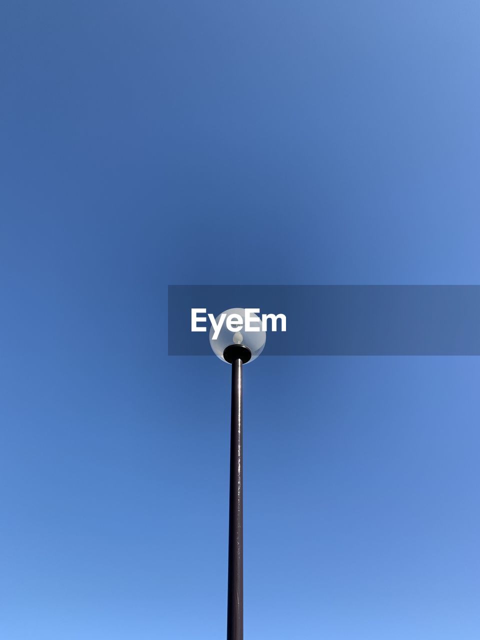 Low angle view of street light against blue sky