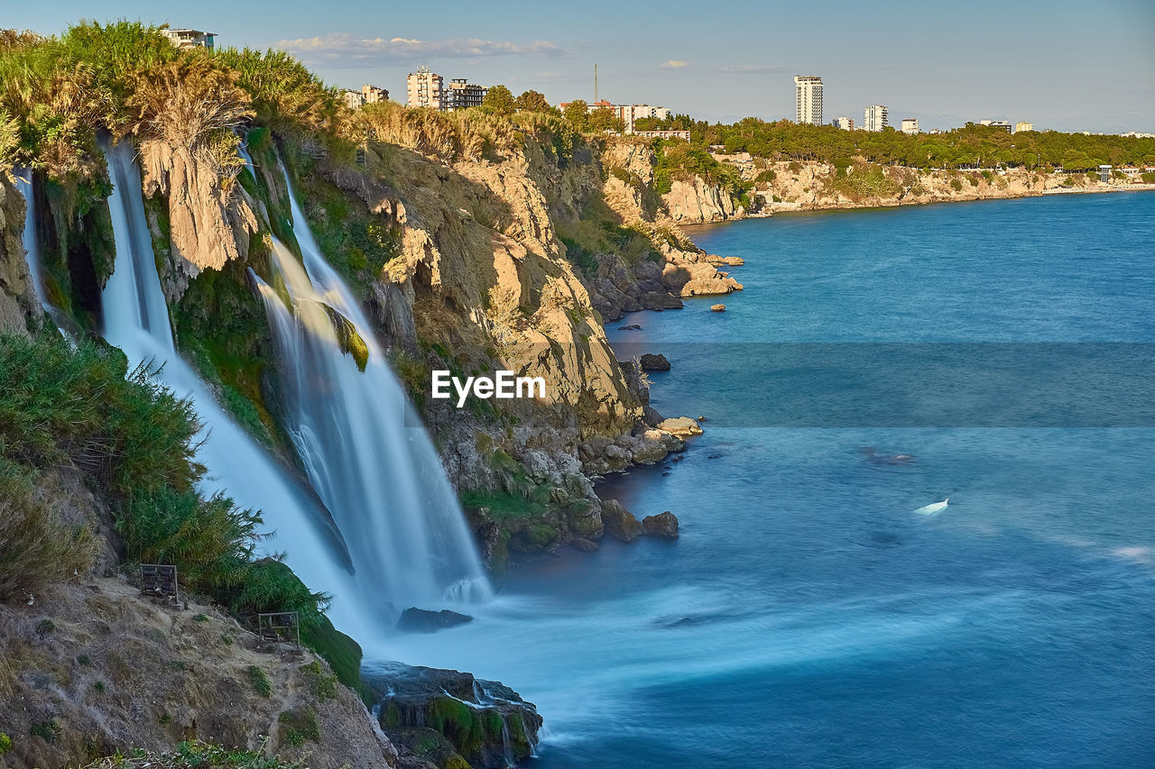 Scenic view of waterfall against sky