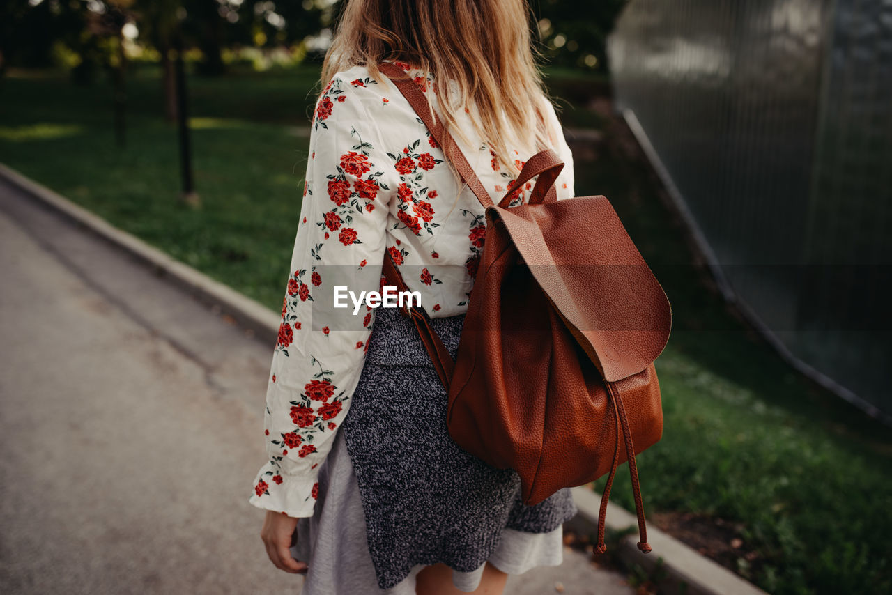 Rear view of woman walking with backpack
