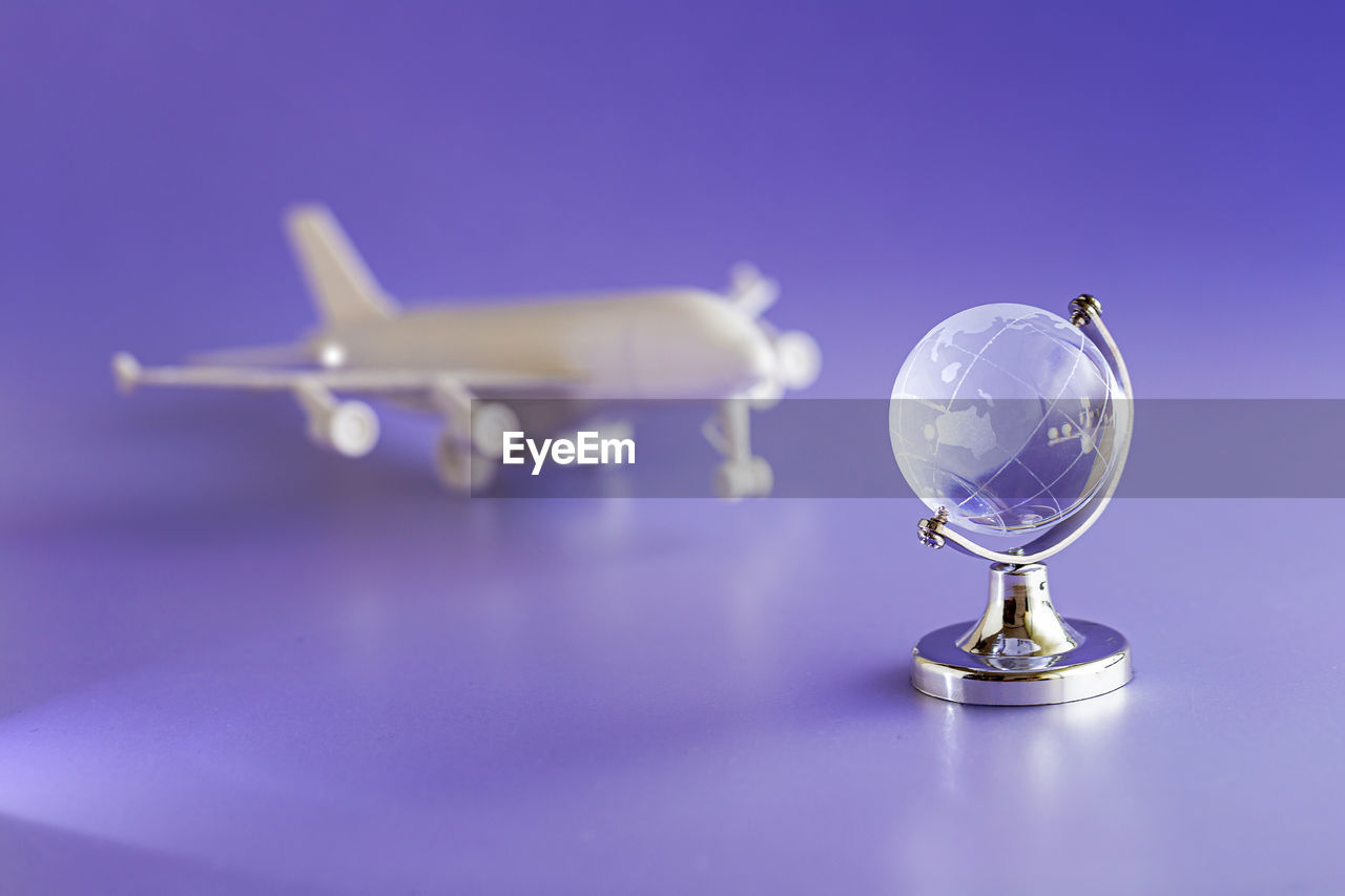Glass globe and airplane model, travel and globalization concept.