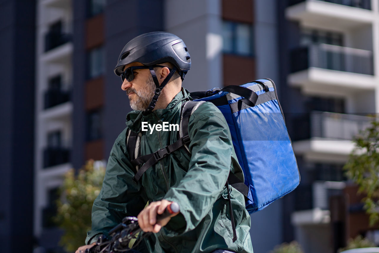 Deliveryman riding electric bicycle in city