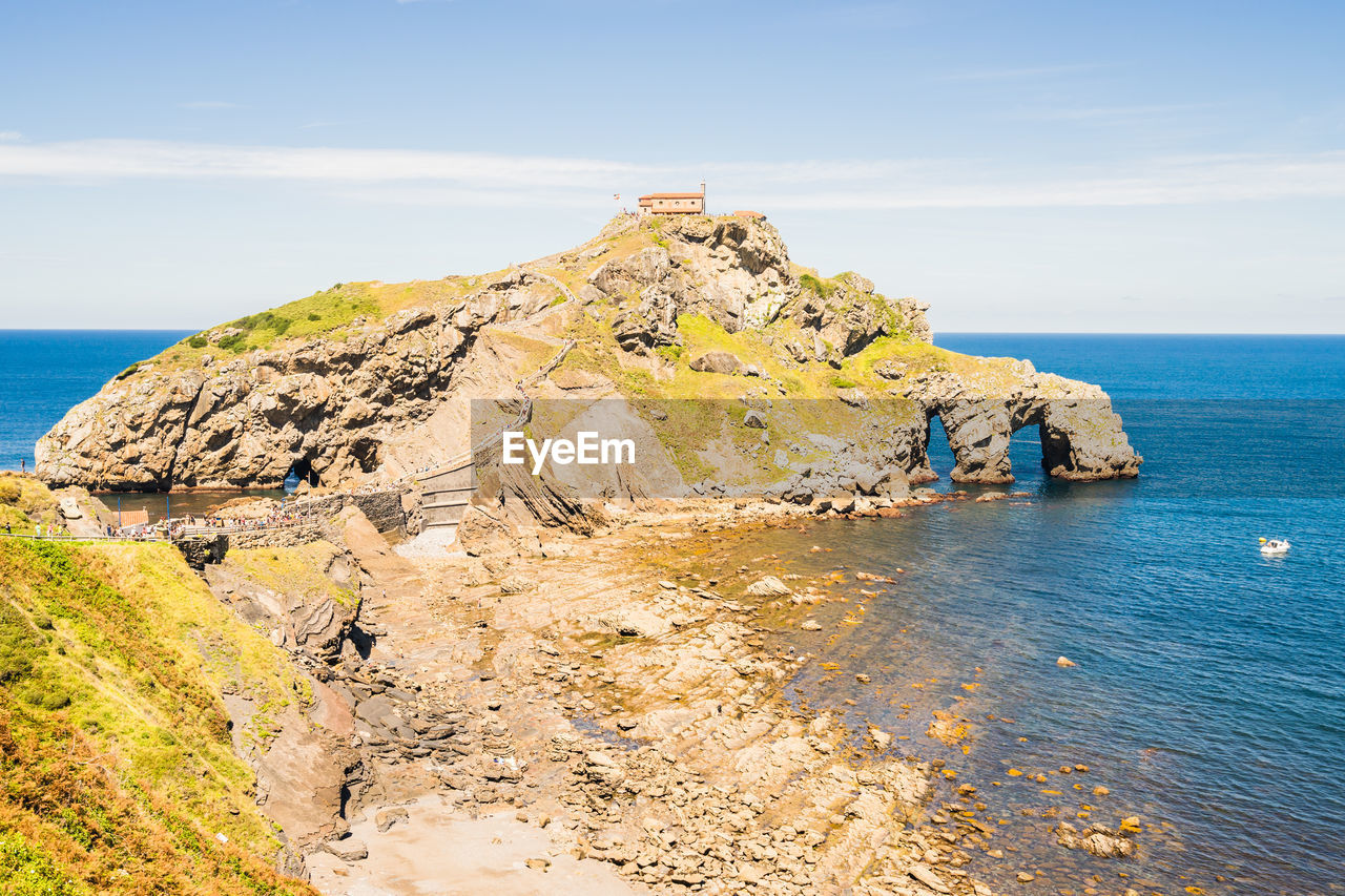 ROCK FORMATIONS ON SHORE AGAINST SEA