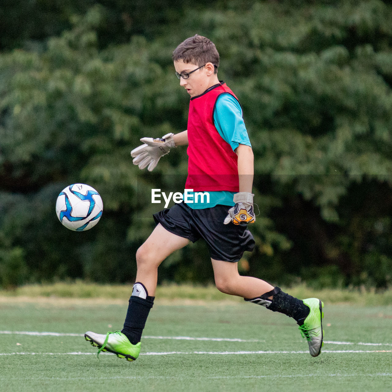 FULL LENGTH OF A BOY PLAYING WITH BALL IN PARK