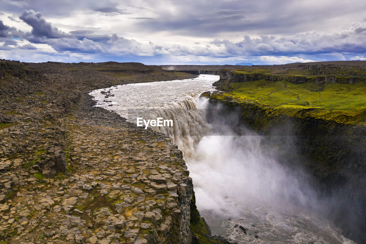 SCENIC VIEW OF WATERFALL AGAINST SKY DURING SUNRISE