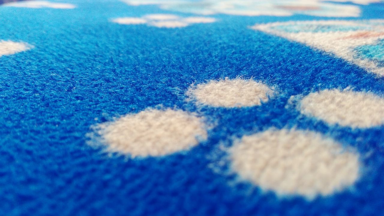 CLOSE UP OF BLUE PATTERN ON TEXTURED SURFACE