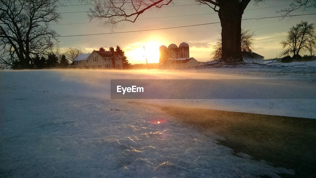 Sun shining over snow covered landscape