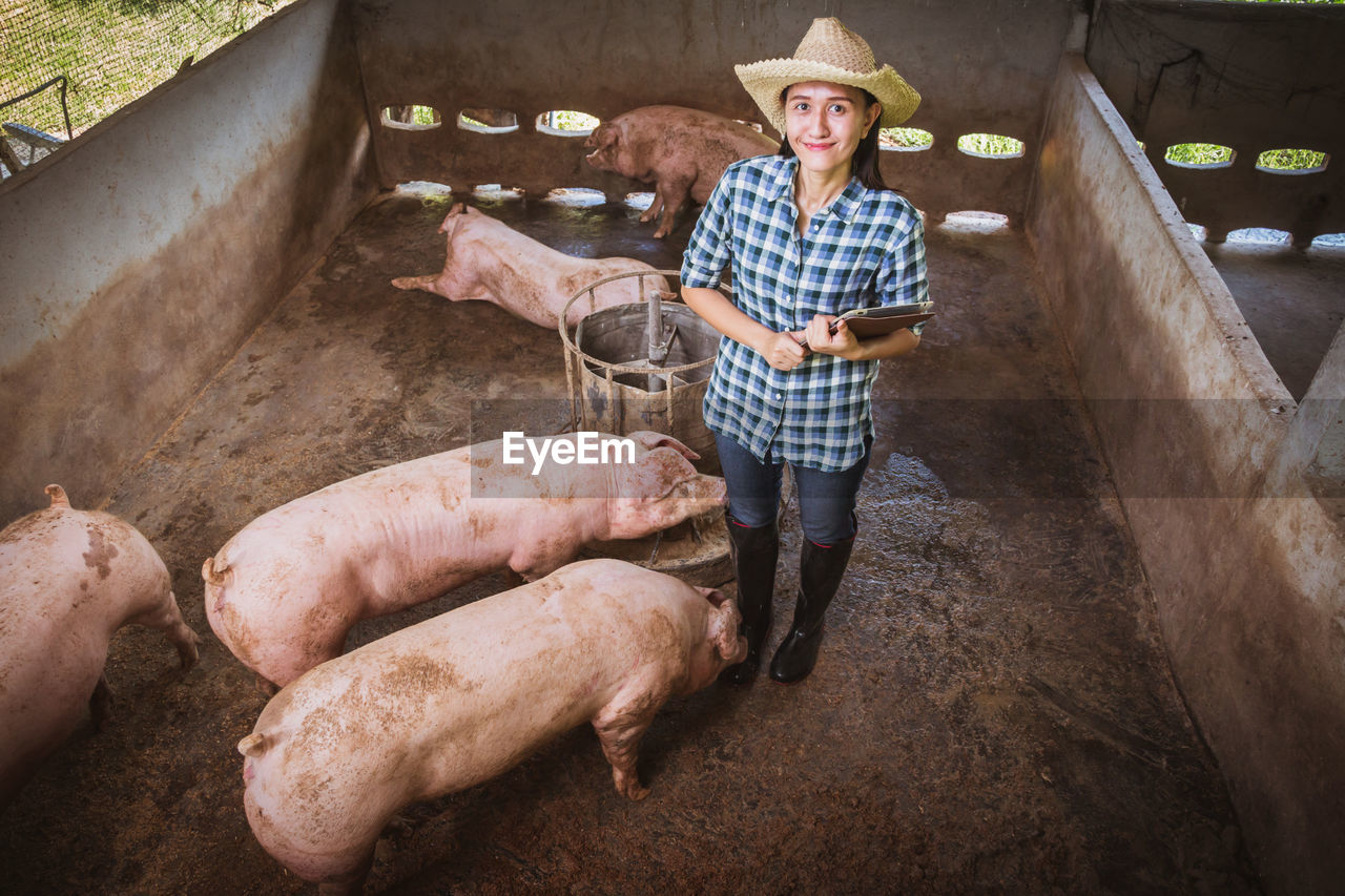 High angle portrait of female veterinarian smiling while standing in shed