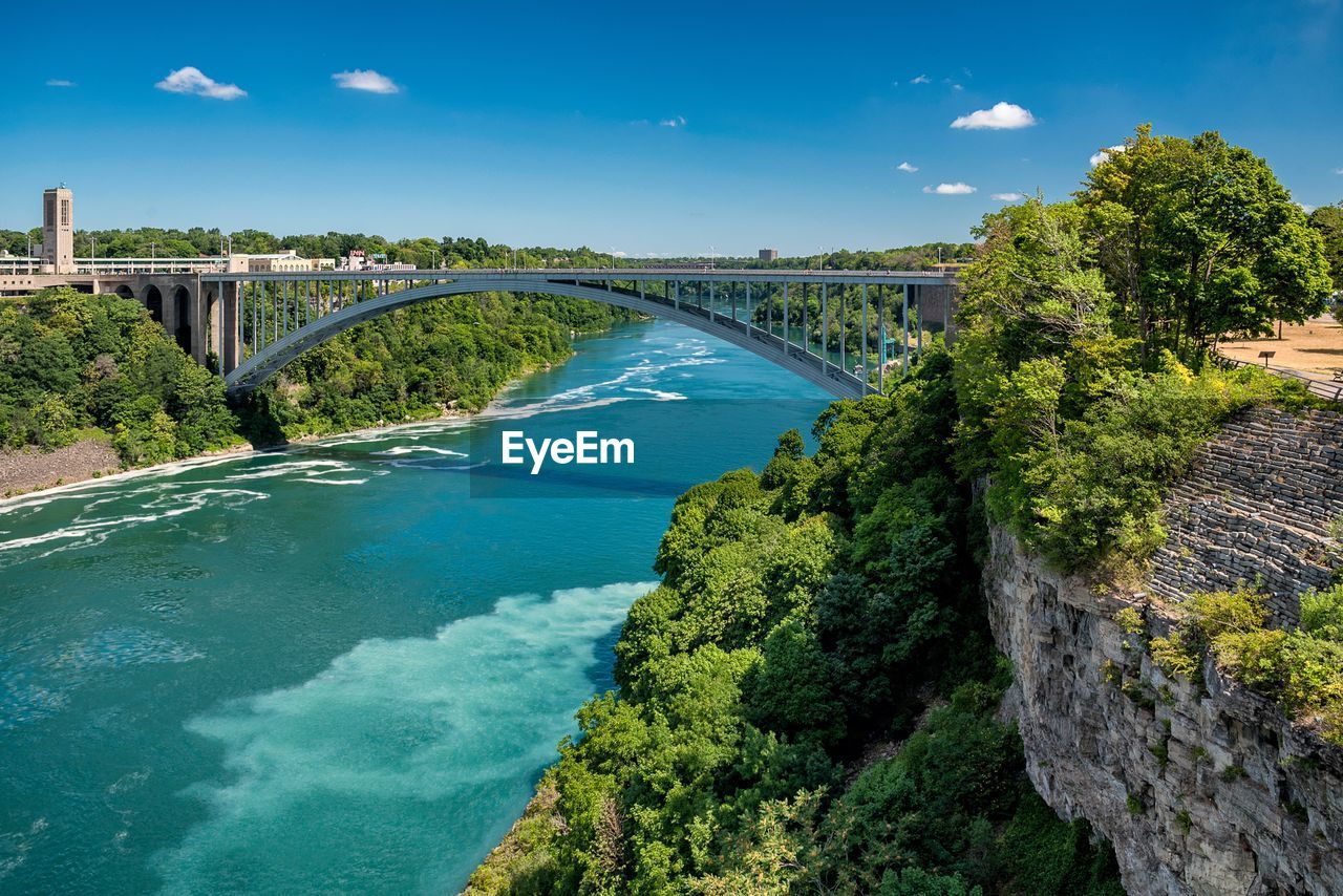 Arch bridge over niagara river against blue sky