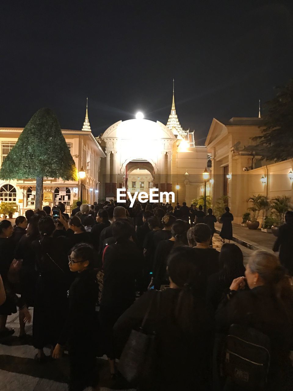 GROUP OF PEOPLE AT TEMPLE AGAINST SKY AT NIGHT