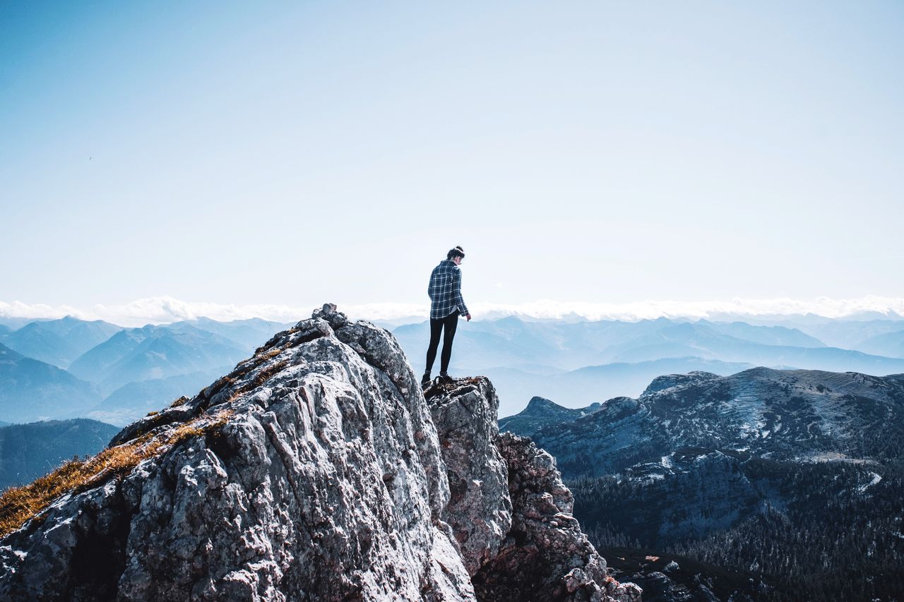 Rear view of woman standing on mountain against sky