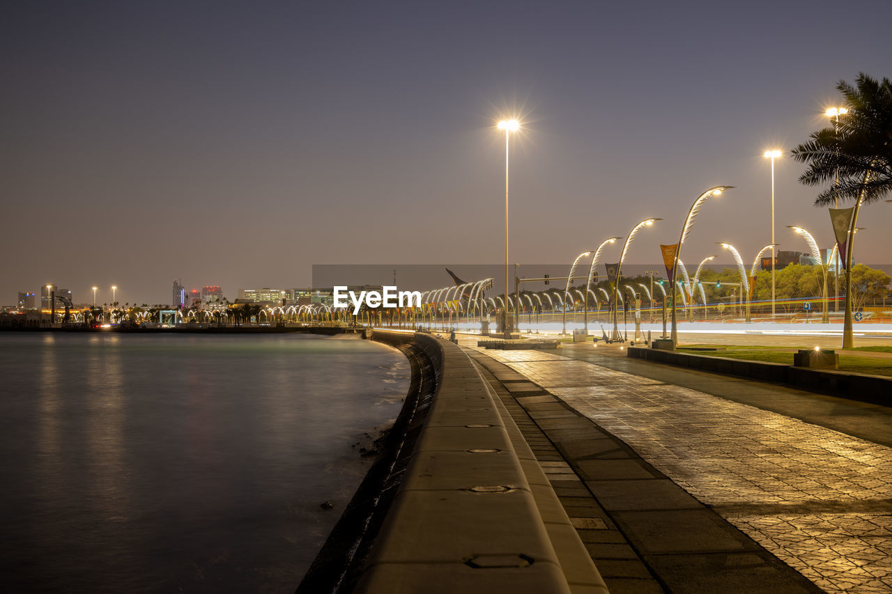 An empty chair along the corniche or the boardwalk overlooking the sea or the bay in doha qatar